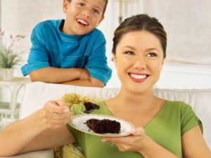 Mother eating a brownie with her son