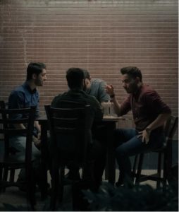 A group of guys sat around having a conversation and getting high