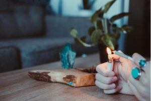 A person lighting a joint over a wooden table