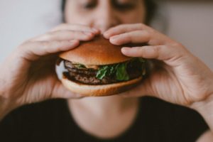 person with a good appetite holding a burger due to cannabis