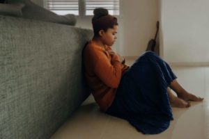 a woman sitting on the floor struggling with anxiety