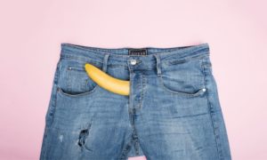 a divine banana sticking out of a pair of men's jeans implying an erection