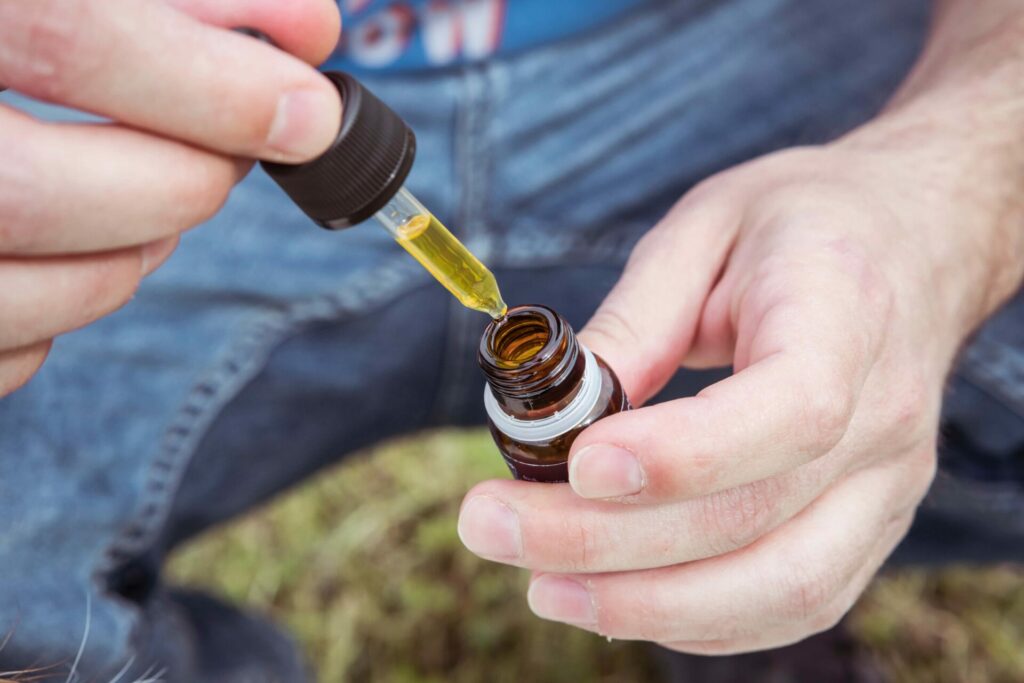 man using THC oil with a dropper